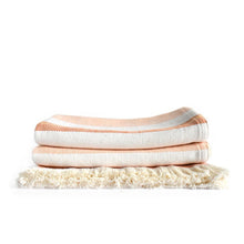 Load image into Gallery viewer, Front view of a folded striped blanket with orange and white pattern and showing fringe.