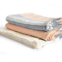 Load image into Gallery viewer, Side view of a folded striped blanket with orange, black and white pattern on a white background.