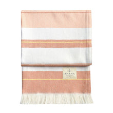 Load image into Gallery viewer, Folded striped blanket with orange and white pattern on a white background, featuring the Amana brand.