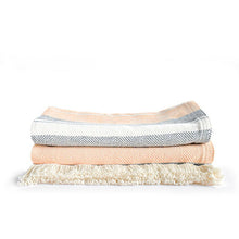 Load image into Gallery viewer, Front view of a folded striped blanket with orange, black and white pattern on a white background.