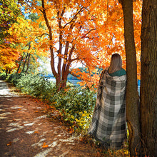 Load image into Gallery viewer, person wrapped in olive grace cotton throw on trail in autumn
