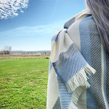 Load image into Gallery viewer, woman wearing light blue Wolter Ridge Wool Throw Blanket standing in a field
