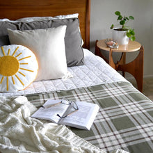 Load image into Gallery viewer, Olive Off the Grid Plaid Cotton Bed Blanket with pillows and book
